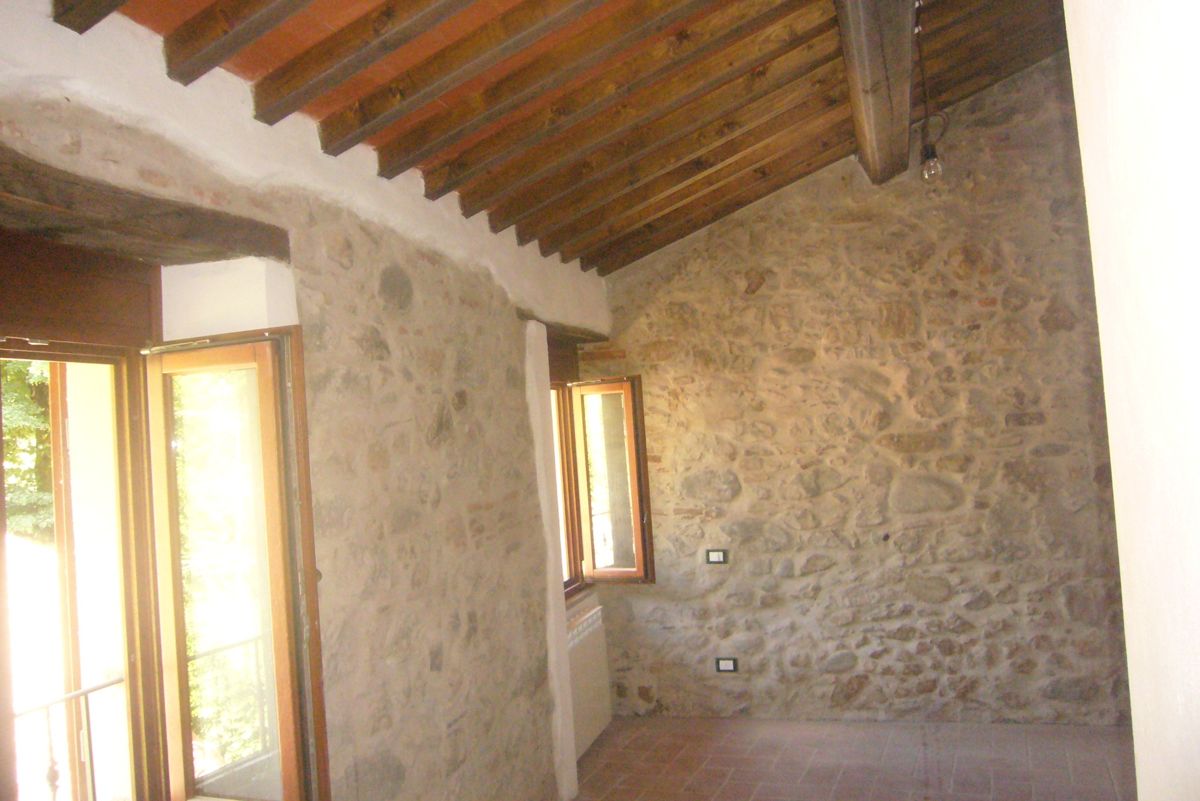 Interno con pareti in pietra e travi in legno
